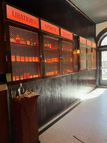 Backlit spirits display cabinetry with mesh doors and Libations and Aperitif signage