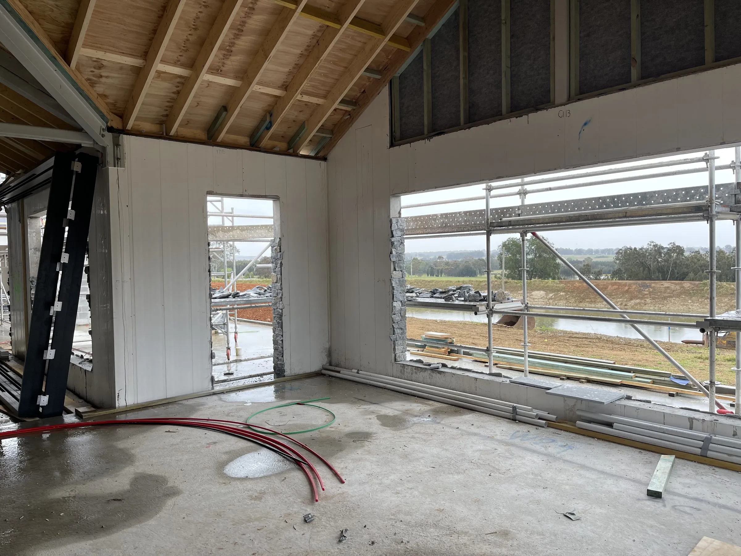Interior renovation in progress with new wall linings and large windows
