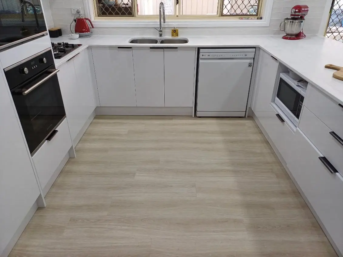 U-shaped kitchen with the sink under the window and a wall oven
