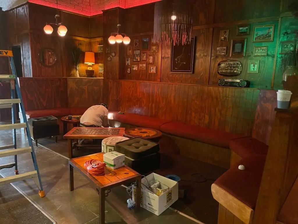 Bench seating being installed against timber panelled walls during a bar fitout
