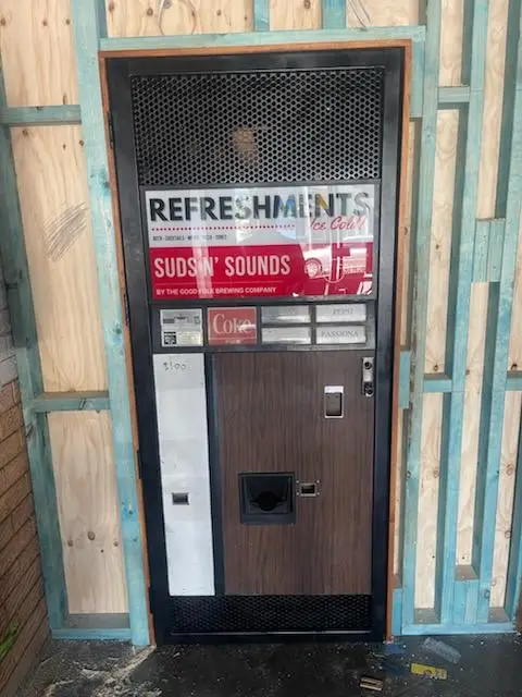 Vintage vending machine set into new stud framing during a bar fitout